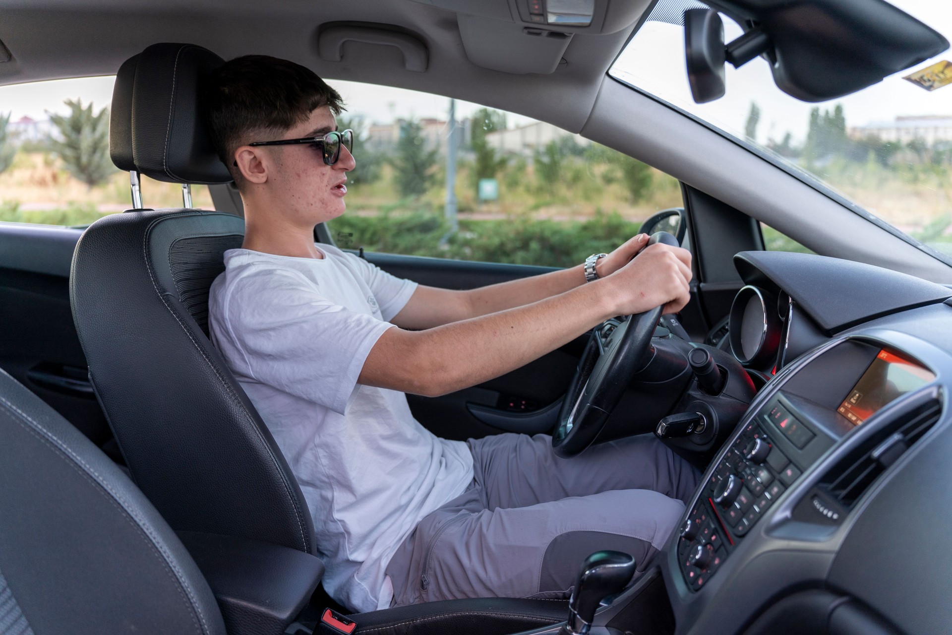 Teenage boy driving a car.